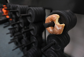 a donut is on a weight rack, a metaphor for a tough life choice