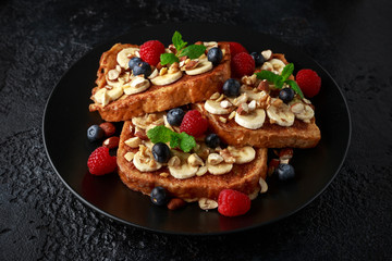 French cinnamon toast with blueberries, raspberries, banana, nuts, hazelnut and honey.