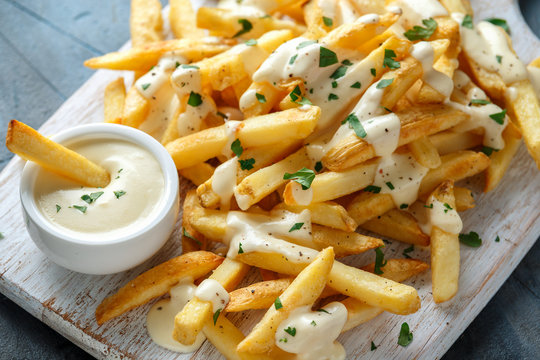 Homemade Baked Potato Fries With Cheese Sauce On White Wooden Board. Closeup