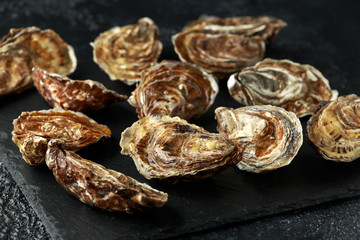 Fresh Oysters on rustic stone board. ready to open and eat