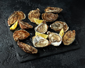 Fresh Oysters platter with lemon and ice. ready to open and eat