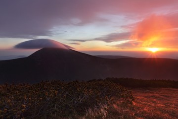 Beautiful sunset on the highest peak and colorful golden red sky, Krkonose (Giant Mountains), Czech...
