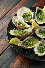 Grilled oysters with Parsley and garlic butter served with parmesan and lemon wedges