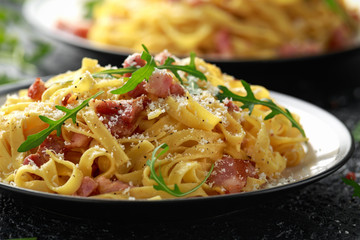 Classic Carbonara pasta, spaghetti with pancetta, bacon, egg, parmesan cheese and green arugula.