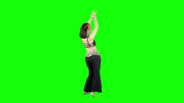 Full length of attractive woman dancing a zumba dance in the studio. Shot in 4k resolution with green screen background