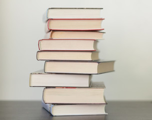 a stack of different books in a thick cover on the table
