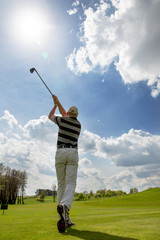 Man playing golf at summer, back view