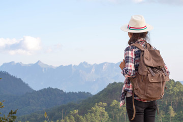 Fototapeta na wymiar Young traveler woman with stylish backpack looking forward at amazing mountains view. Enjoying nature, relax, pleasure.