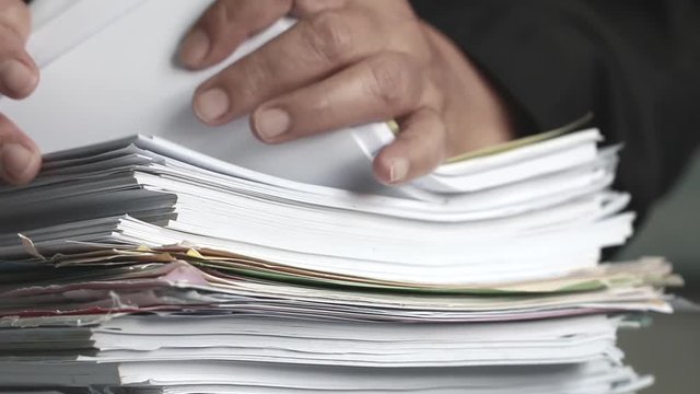 Businessman hands checking documents file paperwork financial market, searching information on work busy desk office. Piles of unfinished document achieves with pen for sigh. Business report  concept