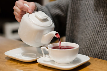 Pouring red tea into a cup