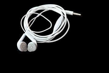 white headphones, earplug on black background, with space for text