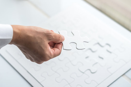 Puzzle game piece on in business person's hand - Powered by Adobe