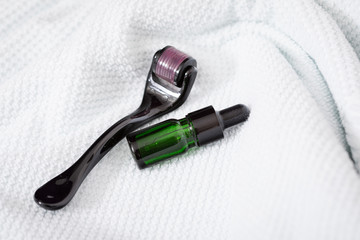 Dermaroller, Handtuch und grüne Beauty Serum Flasche zum  Microneedling für Anti Aging Lifting...