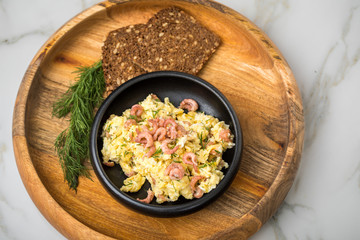 Krabben Rührei mit Friesischen Nordseekrabben, Dill und Schwarzbrot in Holz Schale auf Marmor Hintergrund