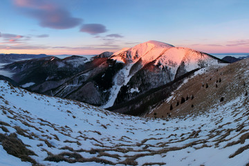 Panoramic view of beautiful winter wonderland mountain scenery in evening light at sunset....