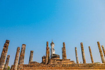 The Buddha image in temple of the old city where called Sukhothai in the sunny day and bkue sky.