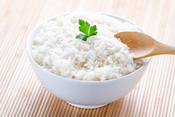 Bowl with white boiled rice with green fresh parsley for delicious healthy lunch. Cereal food and dishes.