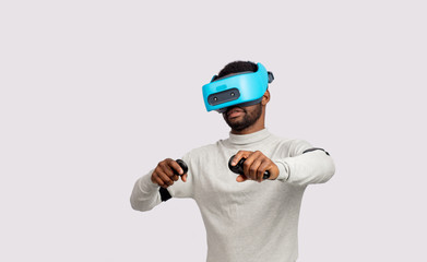 Ethnic dark-skinned bearded male model in virtual reality headset playing tennis in augmented reality. Future. Future technology concept. Isolated on white background.