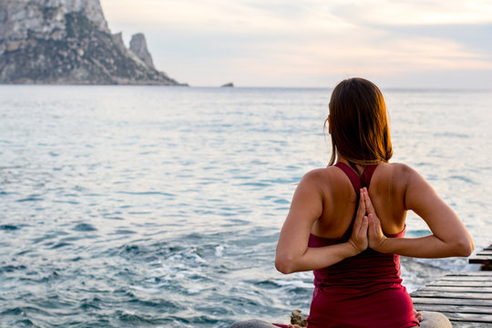 Es vedra, Ibiza : 2015 April 19 : Attractive woman practice yoga at beach with sunset or sunrise in Es Vedra, Ibiza, Spain.