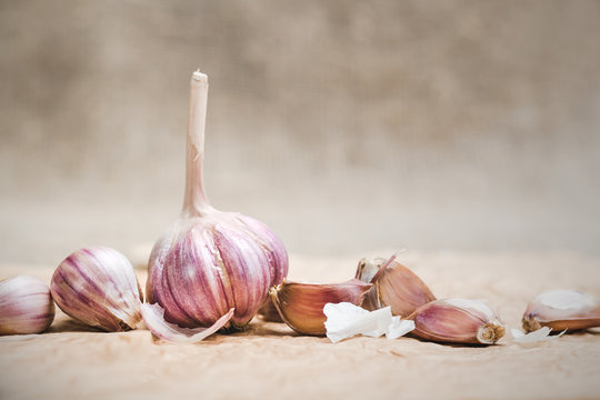 Bulbs and cloves of natural organic garlic on a craft paper