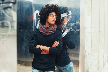 Young Afro american young businessman or student wearing black turtleneck sweater and scarf and having curly dark hair. Concept of stylish and fashionable look