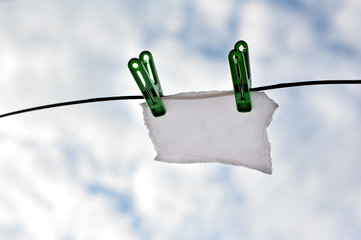 Blank recycle white paper card hanging on clothesline over blur sky background