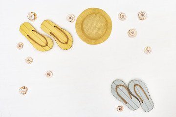 Beach flip flops and straw hat. Summer items on white background. Summer concept. Copy space.