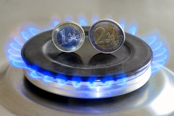 Burning natural gas and euro coins on gas hob