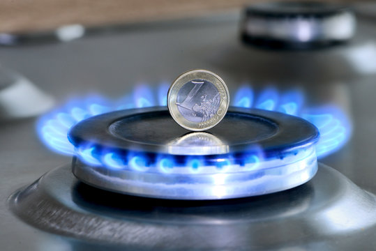 Burning natural gas and one euro coin on gas hob