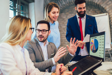 Business colleagues working on laptop in modern office.