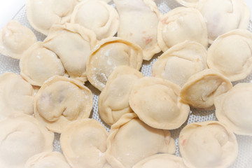 Raw and fresh dumplings lie on a glass plate