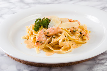Delicious salmon pasta dish, tagliatelle noodles with Parmesan and parsley.