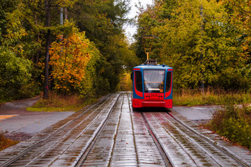 Fototapeta na wymiar Tram rides through the autumn park