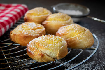 Small vaanilla snails with icing sugar on a cake rack