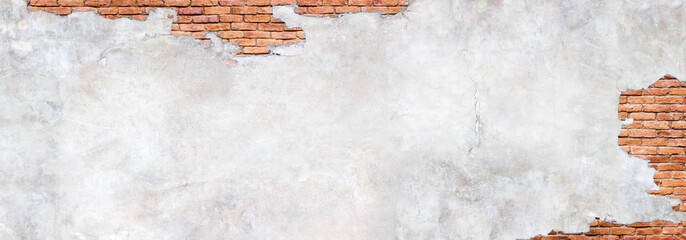 Antique brick wall under damaged plaster. Weathered brickwork texture with cracked concrete