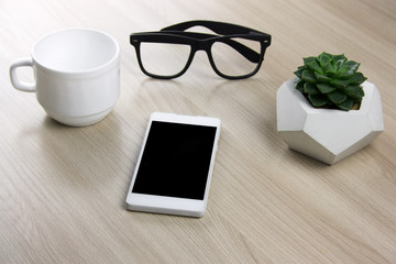 coffee cup, succulent and smartphone  on a wooden table