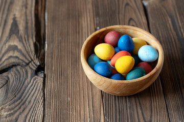 Fototapeta na wymiar traditional painted eggs for easter in a wooden bowl on a wooden background