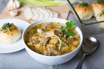 Shchi (cabbage soup) with buns (pampushki), fat and garlic. Traditional Russian and Ukrainian soup. Selective focus, close-up.