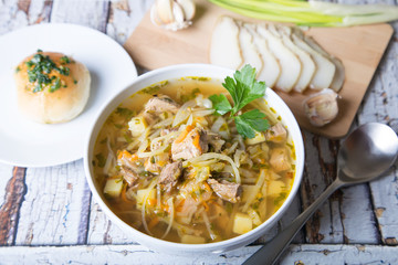 Shchi (cabbage soup) with buns (pampushki), fat and garlic. Traditional Russian and Ukrainian soup. Selective focus, close-up.