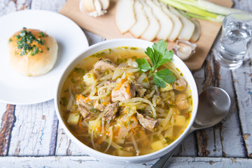 Shchi (cabbage soup) with buns (pampushki), fat and garlic. Traditional Russian and Ukrainian soup. Selective focus, close-up.