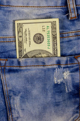 Twenty dollars bill in the pocket of blue jeans