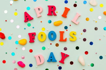 inscription April Fools Day in colorful bright wooden letters on a blue background with a holiday serpentine.