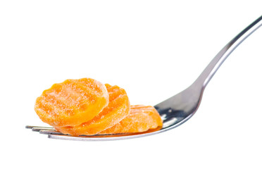 Frozen carrots on fork macro on white background isolation