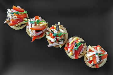 Delicious French snack with ham, cheese, pepper and tomato in tartlets. Top view. Concept of food,...