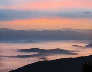 quiet mountain valley in a blue mist at the dawn