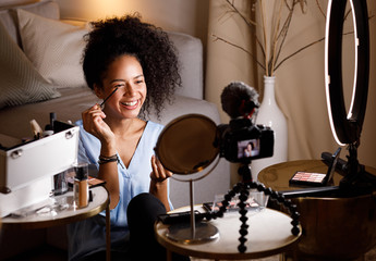 Female vlogger recording makeup tutorial for her channel