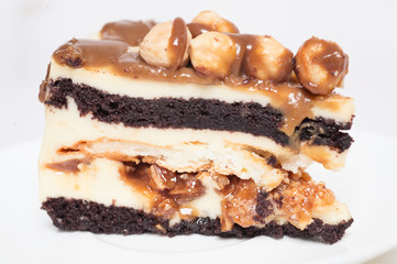 piece of cake with caramel and hazelnut at white background
