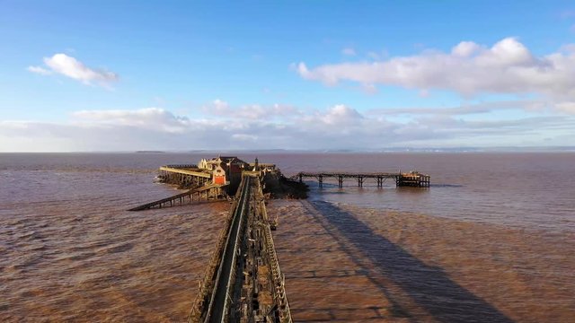 Aerial sequence depicting Birnbeck Pier, Weston-super-Mare, Somerset. The derelict pier, built in 1867 is the only pier in the country which links the mainland to an island. Closed to the public.