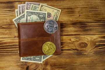 Wallet with american dollars bills and bitcoins on wooden background