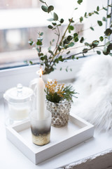 Interior tray decoration with burning candle, mimosa flowers and branches